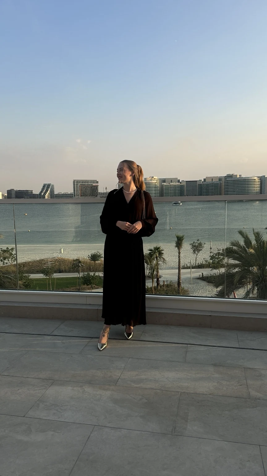 Original photograph of Leoni at a waterfront terrace, now labelled Apex Invest Abu Dhabi